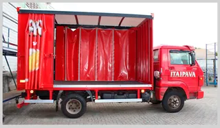 Caminhão vermelho Itaipava com cortinas sider vermelhas recolhidas